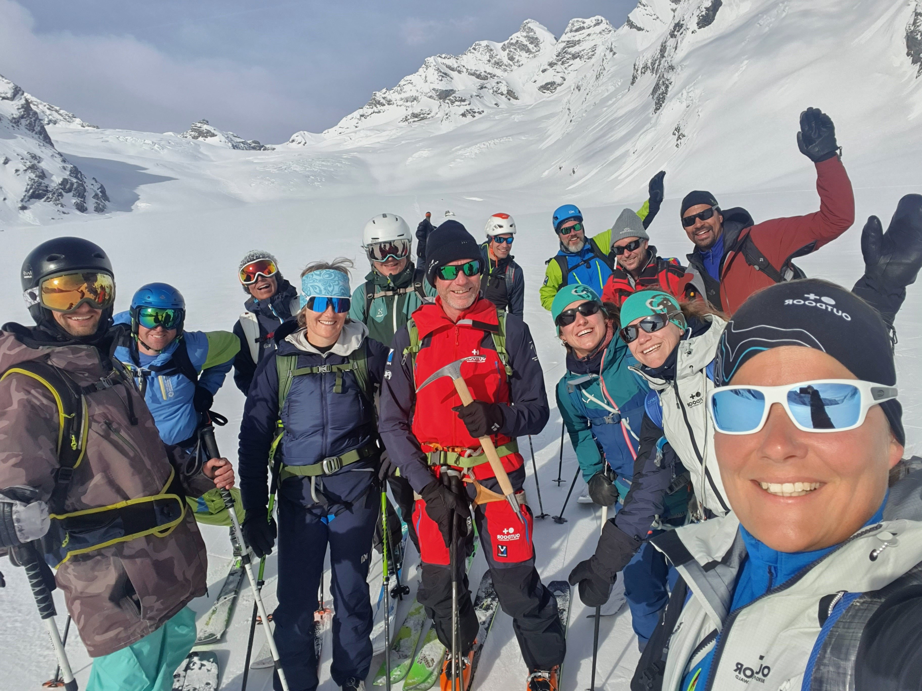 Group of skiers with helmets and ski goggles in snowy mountains.