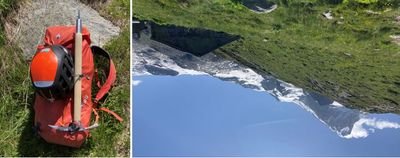 Red backpack with helmet and ice pick on grass; mountain landscape in the background.