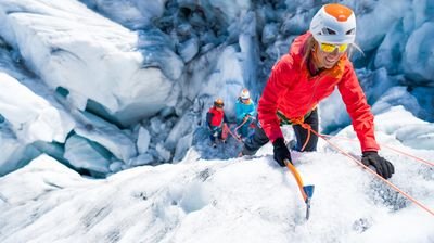 Bergsteiger klettert mit Pickel im Eis