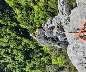 Climber on ridge with trees in the background