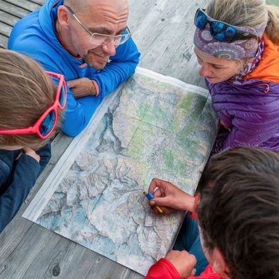 Vier Personen schauen sich ein Wanderkarte an.