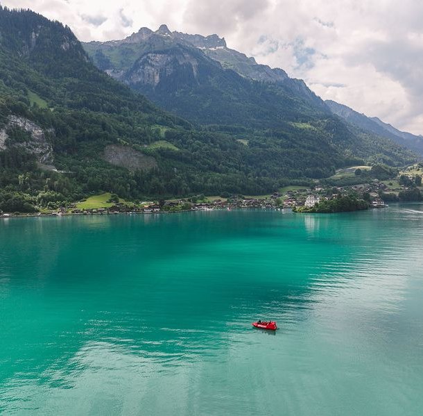 Jet boat on the turquoise blue Lake Brienz in front of Iseltwald.