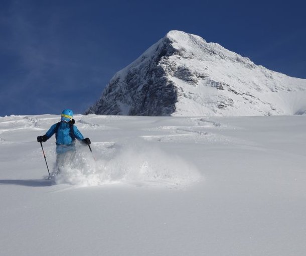 Person skiing in deep snow with the Eiger in the background.
