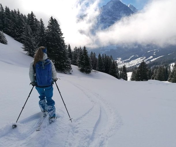 Person skiing in deep snow with the Eiger in the background