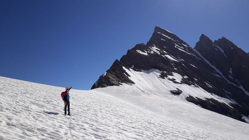 Mountaineer points with finger at summit