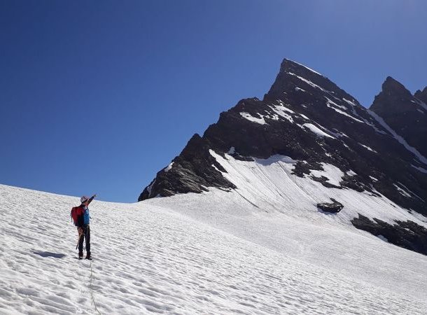 Mountaineer points with finger at summit