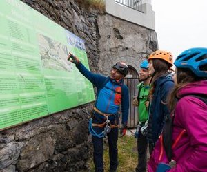 Mountain guide points to information board at the start of the via ferrata Mürren