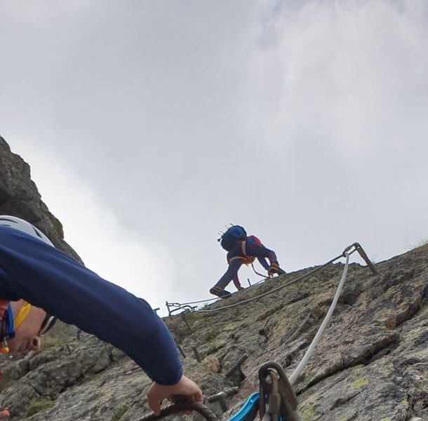 Person climbs a vertical section of the Tierbergli via ferrata