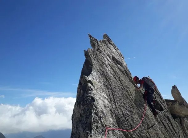 Climber climbs on rock needle