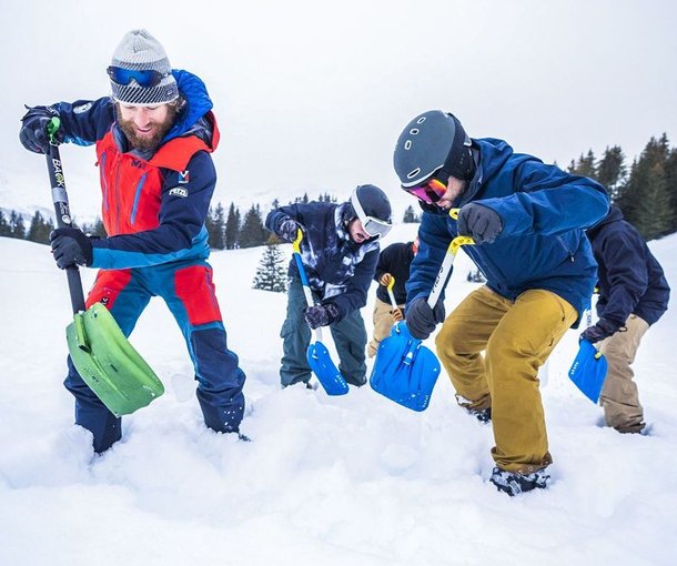 Personen üben Lawinenrettung