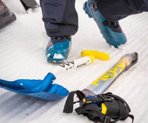 Avalanche shovel, avalanche probe, and avalanche transceiver in the snow.
