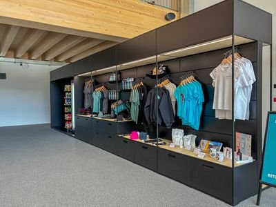 Merchandise display with clothing, helmets, and accessories in a modern retail space.