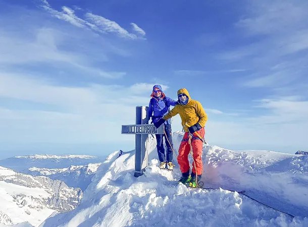 Ski tourers at the summit cross of the Finsteraarhorn.