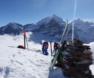Ski tourers and cairn on the summit of Schwarzhorn.