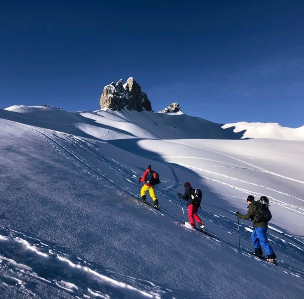 Ski tourers ascending with the Lobhorn mountains in the background.