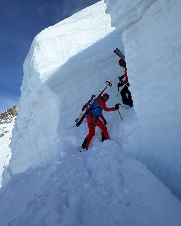 Ski tourer with skis strapped on in the glacier crevasse.