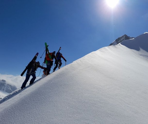 Ski tourer with skis strapped on the ridge.