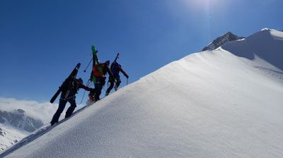 Ski tourer with skis strapped on the ridge.
