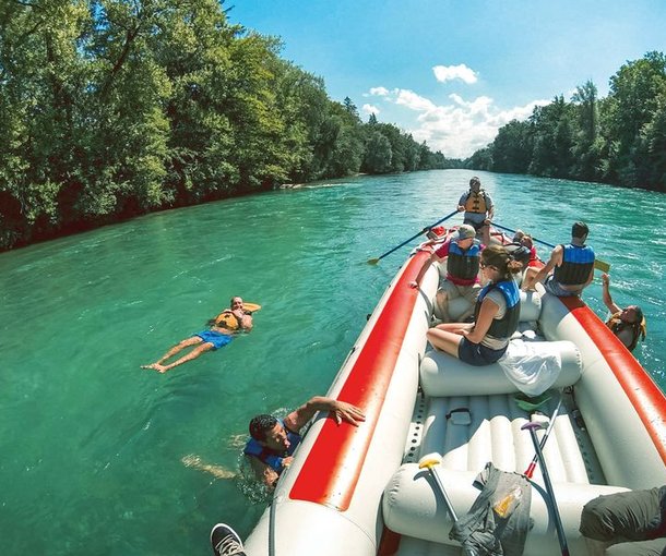 People on a raft during the Aare river cruise, some participants let themselves drift next to the boat