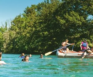 People swimming in the Aare next to the raft during the Aare Float Trip