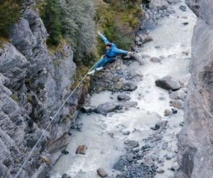 Person schwingt über Fluss beim Canyon Swing in Grindelwald