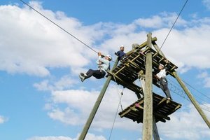 Mehrere Personen stehen auf einem hölzernen Podest im Seilpark Rigi