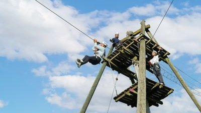 Mehrere Personen stehen auf einem hölzernen Podest im Seilpark Rigi